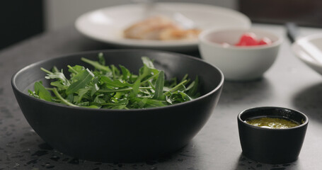 arugula in black bowl on concrete countertop