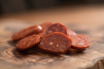 Slices of chorizo on olive wood board