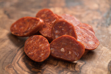 Slices of chorizo on olive wood board