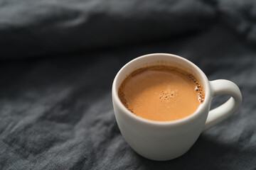 hot espresso in white cup on linen cloth with copy space