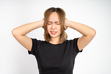 asian woman with annoyed expression covering ears with both hands on isolated background