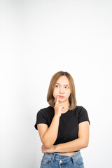 Thoughtful Asian woman poses against isolated background. girl looks confuse and thinking