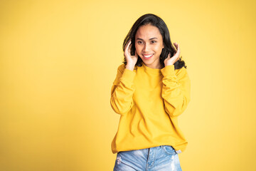 attractive asian ethnicity female looking at camera smiling with fun gesture on isolated background