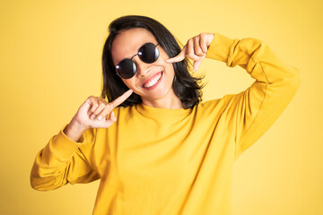 happy asian woman laughing while holding her cheeks. excited beautiful woman feeling joy on isolated background