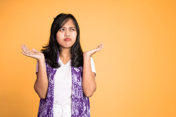 woman opening two palms does not know what to do on isolated background feeling uncertain