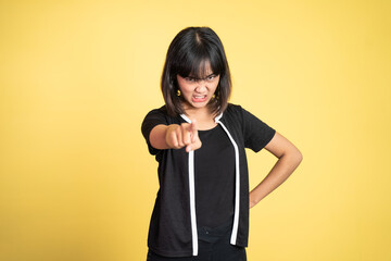 unhappy and angry asian woman with finger pointing to camera