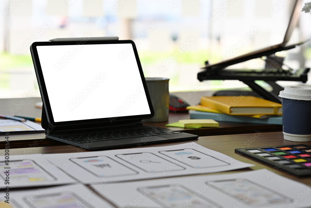 Aufkleber front view close up of white screen tablet with standing stuff and document papers on the wooden des