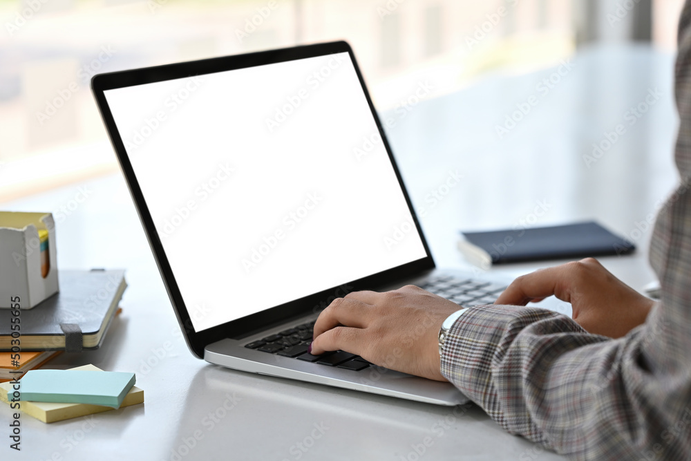 Poster close up side view of an adult female in a suit typing something with an empty monitor screen of a l