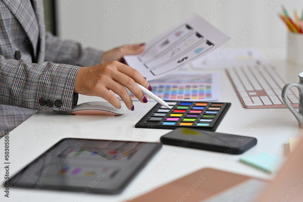 Poster close up of a female designer choosing a new color for a layout media design on hand next to digital