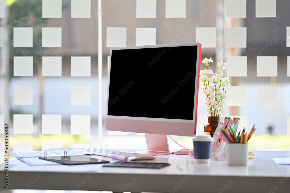 Poster close-up front view of a black computer monitor screen with accessories on the white busy desk over 