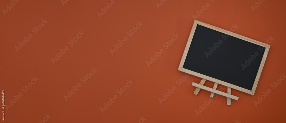 Poster there is a top position view of an empty black screen board with a rectangle wooden frame standing o