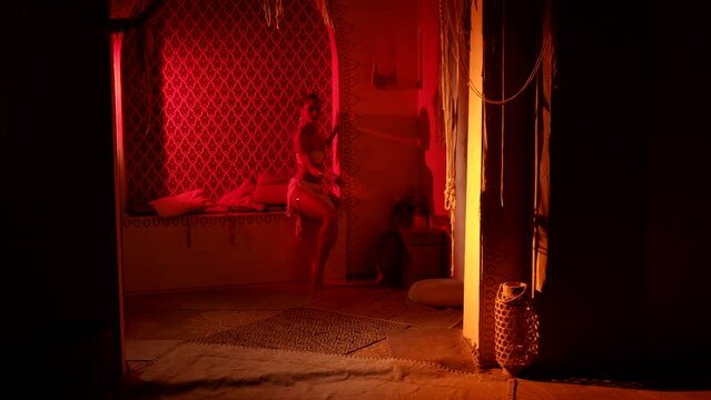 seductive arabian princess is dancing in ancient palace in night, sexy busty lady is moving slowly