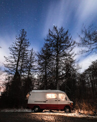 Vertical shot of a Mercedes Benz Astro van parked in a forest