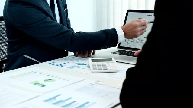 Business meeting, Businessman is summarizing financial graphs and analyzing market trends from a laptop to develop a company's revenue, Brainstorming or Discussing concept.