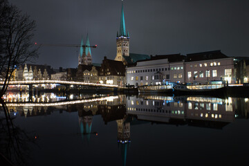 Cityscape of Lubeck at night with St. Mary's church reflected on Trave river