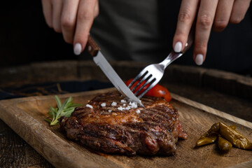 grilled meat steak on a wooden board with spices in a premium restaurant

