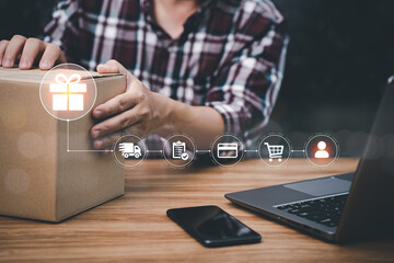 Parcel delivery concept: A man received a parcel box from an online order and delivery virtual interface icons shopping online with laptop and smartphone on the table