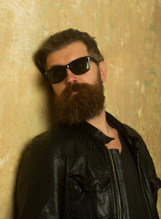 Fototapeta na wymiar Confident attractive man with serious face. Portrait of handsome man. Bearded hipster on beige wall background.
