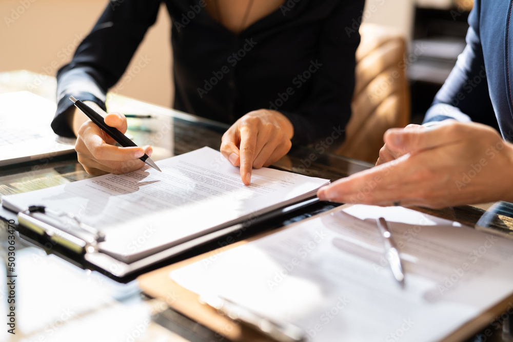 Wall mural Two Businesspeople Working On Contract Paper