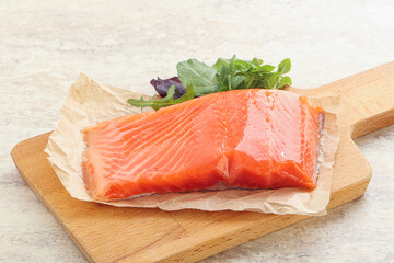 Raw salmon fillet over board