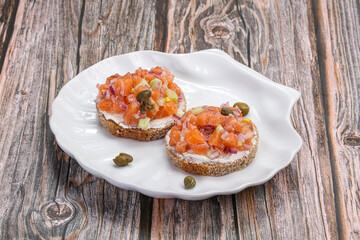 Salmon tartar over bread served capers