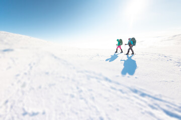 Fototapeta na wymiar Two women walk in snowshoes in the mountains
