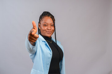beautiful african woman smiling as she gives direction with her hand.