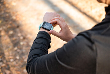 Girl checking smart watch with fitness tracker, looking at health data while exercising, touching the screen
