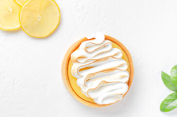 Mini lemons tart with cream on white background. Lemons slices and green leaves 