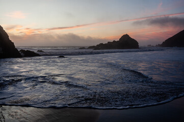 Water from the pacific ocean washing ashore on Pfeiffer beach, around sunset.