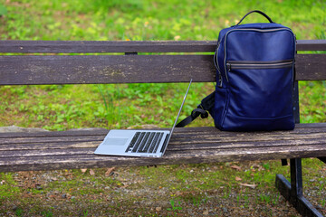 公園のベンチ　ノートパソコンとリュック　モバイル　イメージ