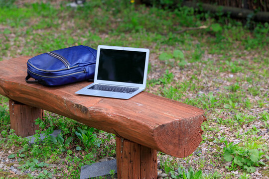 公園のベンチ　ノートパソコンとリュック　モバイル　イメージ