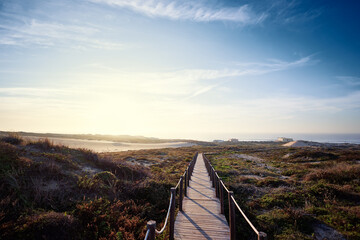 Wooden pedestrian walkway through Sintra-Cascais natural park. Wild sandy landscape, with part of...