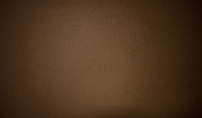 Photo of the texture of a brown background made of soft felt fabric.Rag brown background with black...
