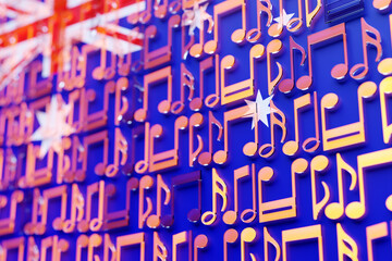 Musical notes lined up in even rows against the backdrop of the National Flag of Australia. The concept of the national anthem, music