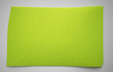 A piece of felt fabric of light green color. Pure green fabric on a white background.