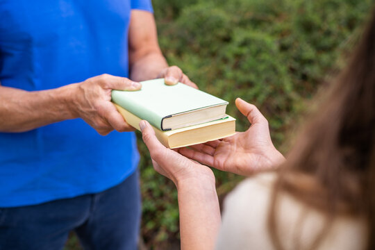 Sharing Books. Hand Closeup Giving Book