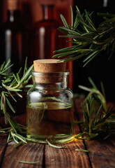 Rosemary essential oil or infusion on an old wooden table.