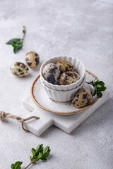 Bowl with quail eggs on light background