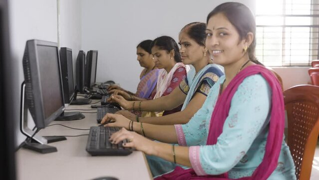 group of Smiling women showing thumbs up by looking camera during computer training class - concept of women employment, learning and education