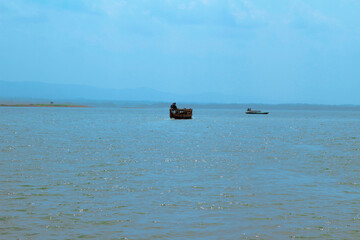 Beautiful Kaptai Lake in Rangamati Bangladesh. Wooden boats on the water, surrounded by mountains.