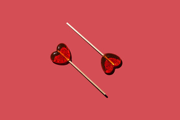 two lollipops hearts on a red background pattern