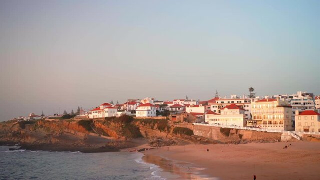 Praia das Macas Apple Beach in Colares, Portugal, on a stormy day before sunset Small city on ocean shore