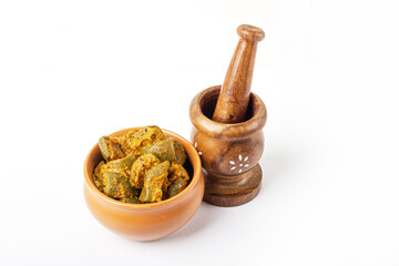 Mango Pickle in brown bowl with Wooden mortar on white background