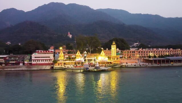 holy ganges riverbank filled with religious temples at evening aerial shot