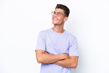 Young caucasian man isolated on white background looking up while smiling