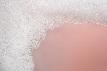 Fluffy white foam on a pink background.