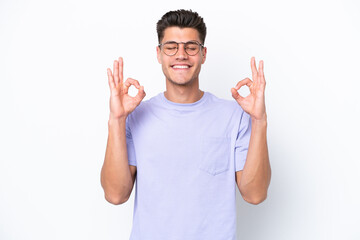 Young caucasian man isolated on white background in zen pose