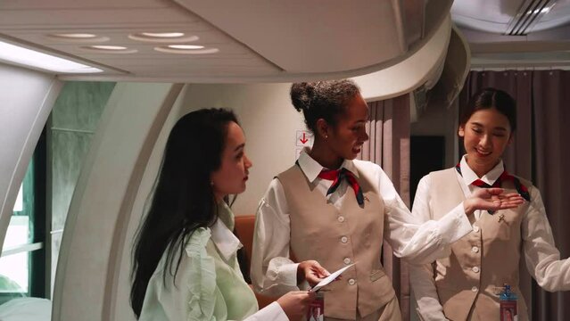 Multiracial passengers boarding airplane with boarding pass inspect by two flight attendants