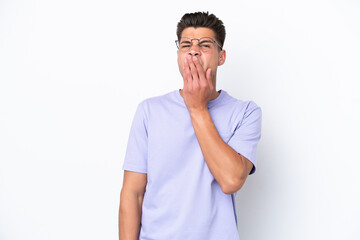 Young caucasian man isolated on white background yawning and covering wide open mouth with hand